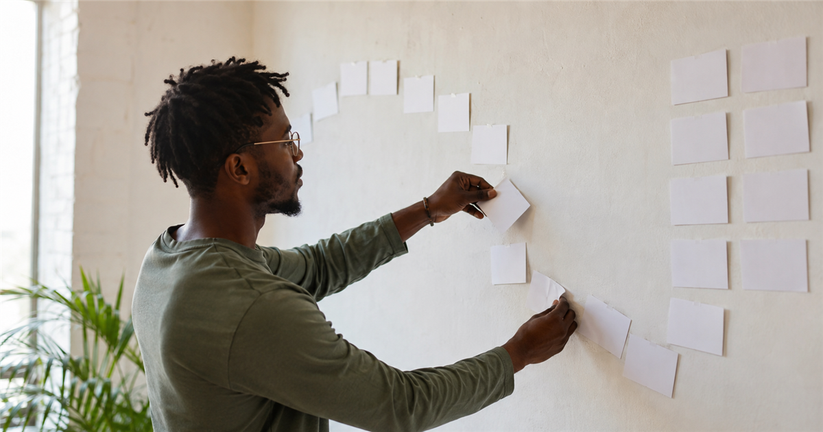 A writer arranges blank cards into a flexible path instead of a rigid grid.